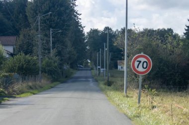 Dordogne Fransa 'daki ağaçların arasında yol kenarı hız sınırı tabelası