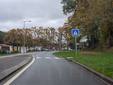Sonbaharda Dordogne Fransa kırsalında yaya geçidi tabelası olan bir yol.