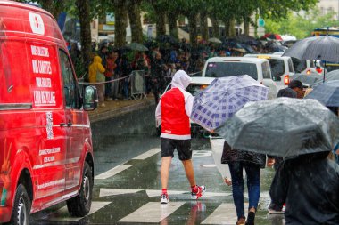 Fransa, 22 Mayıs 2024: Şemsiyeler ve Kırmızı Dağıtım Van Caddesi ile Yağmurlu Gün Kalabalığı