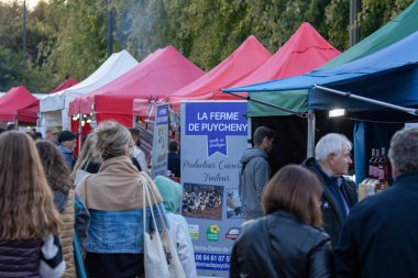 Fransa, 28 Eylül 2024: Renkli satıcı çadırlarıyla kalabalık açık hava pazarları.