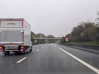 Dordogne Fransa 'da hız işareti olan ıslak otoyolda bir kamyon.