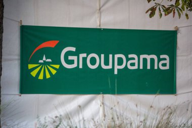 Fransa, 28 Eylül 2024: Ağaçlar ve minimalist yeşil tasarımlı Groupama pankartı