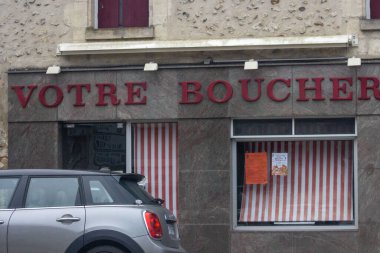 Fransa, 17 Kasım 2024: Çizgili pencere ve araba kaplamalı kasap dükkanı mağazası.