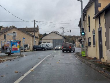 Fransa, 19 Kasım 2024: Araçlar ve trafik işaretleriyle küçük kasaba caddesi sahnesi.