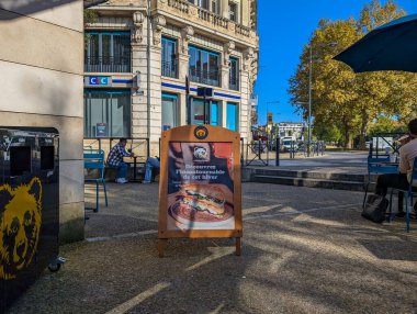 Fransa, 03 Kasım 2024: Reklamlı açık kafe sahnesi ve öğleden sonra eğlenen insanlar.