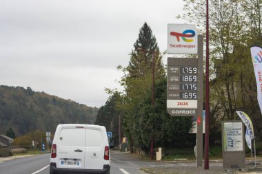Fransa, 17 Kasım 2024: TotalEnerjiler doğalgaz fiyatları ve park edilmiş kamyonetin yer aldığı yol kenarı manzarası.