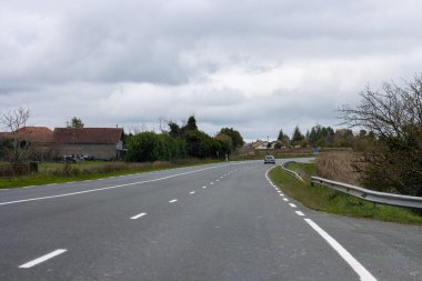 Dordogne Fransa 'da kırsal evlerden geçen arabalı virajlı yol