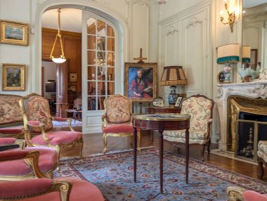 Fransa, 22 Eylül 2024: Süslü mobilya ve klasik sanat eserlerinin sergilendiği zarif tarihi salon.