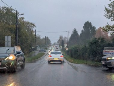 Yağmurlu kırsal yolda arabalar ve bulutlu gökyüzü Dordogne France