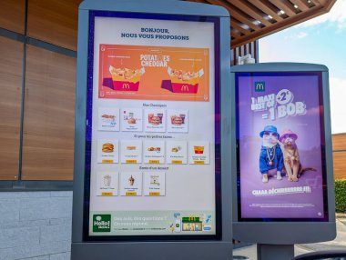 Fransa, 7 Temmuz 2024: McDonald 's dijital menü tahtası ve restoran dışındaki tanıtım tabelası