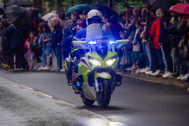 Fransa, 22 Mayıs 2024: Polis motosikleti seyircilerle yağmurlu sokakta geçit töreni düzenledi