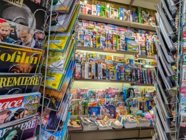 Fransa, 11 Kasım 2024: Dergiler kalabalık bir gazete bayiinde raflarda sergilendi.