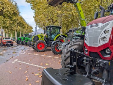 Fransa, 27 Eylül 2024: Sonbahar ağaçlarının altına park edilmiş traktörler sergisi