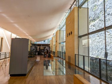 Fransa, 07 Temmuz 2024: İçinde cam duvarlar ve sergiler bulunan modern müze koridoru