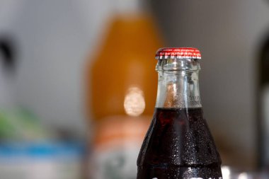 Fransa, 12 Ağustos 2024: Soda şişesi yoğunlaşması ve bulanık arka plan içecek sahnesi