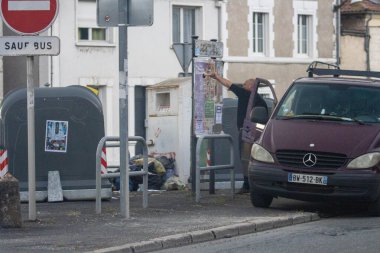 France, 08 September 2024 : Man Posting Notices Beside Mercedes Van Near Recycling Bin clipart