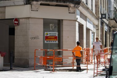 France, 05 August 2024 : Busy street with construction barriers and commercial property for rent clipart