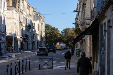 Fransa, Bordeaux, 05 Ekim 2024: Arabalar, yayalar ve tarihi binalarla dolu kentsel cadde.