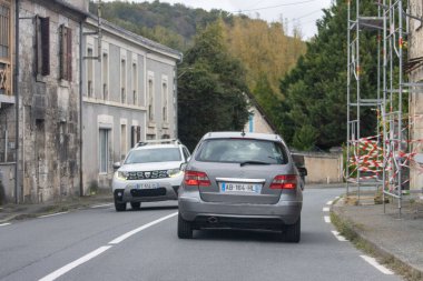 Fransa, 10 Kasım 2024: İnşaat iskelesi yakınlarında dar yolda iki araba