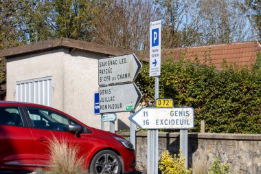 Fransa, 01 Kasım 2024: Kırsal Fransız köyünde yol işaretleri ve park edilmiş kırmızı araba