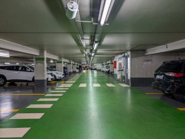 Fransa, 11 Eylül 2024: Park etmiş arabaları ve aydınlatması olan boş yeraltı otopark koridoru