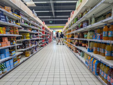 Fransa, 10 Ağustos 2024: Alışveriş yapanlar, iyi ışıklandırılmış süpermarket iç koridorlarında İçecek Koridorlarına Bakıyorlar