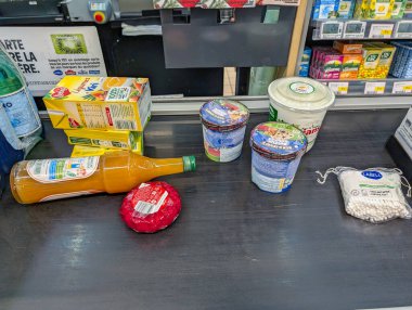 France, 16 November 2024 : Groceries on checkout counter including juice ice cream cheese clipart