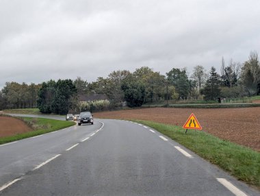 Kırsal yol kavislerinde arabalar ve inşaat tabelası Dordogne France