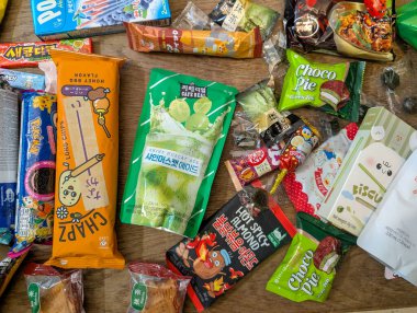 Fransa, 19 Aralık 2024: Ahşap masaya yayılmış çeşitli renkli atıştırmalıklar ve ikramlar