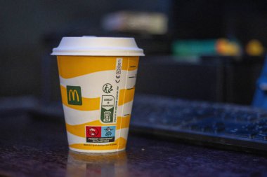 France, 02 December 2024 : McDonald's coffee cup near keyboard in dimly lit setting clipart