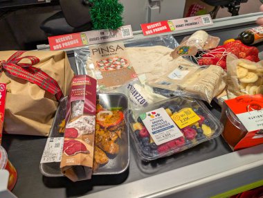 Fransa, 24 Aralık 2024: Bayram sezonu alışverişi sırasında taşıma bandındaki bakkallar.