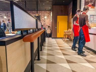 Fransa, 11 Aralık 2024: Fast food restoranının içi kırmızı önlük giyen çalışanlarla dolu