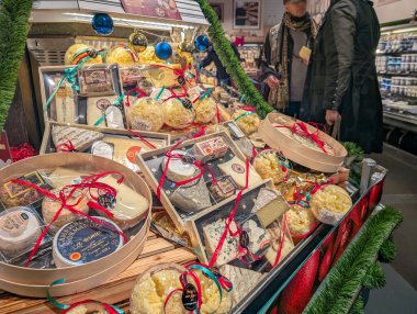 France, 21 December 2024 : Holiday cheese display with colorful ribbons in grocery store clipart