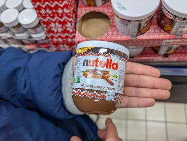 Fransa, 07 Aralık 2024: Bir mağaza koridorunda Nutella kavanozu tutan kişi