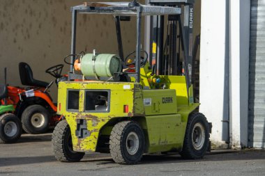 Fransa, 17 Aralık 2024: Endüstriyel ekipman ve makinelerin yakınına park edilmiş yaşlı bir forklift