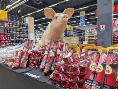 Fransa, 23 Ocak 2025: Dolu süpermarket ortamında paketlenmiş etler arasında domuz heykeli