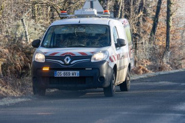 Fransa, 31 Aralık 2024: Ormandan geçen çizgili uyarı işaretli kamu minibüsü.