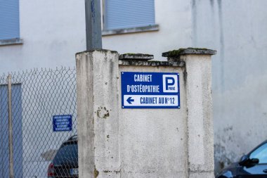 Fransa, 20 Aralık 2024: Beton duvardaki imza klinik için özel park yeri olduğunu gösteriyor