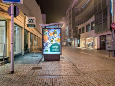 Fransa, 31 Aralık 2024: Foggy Caddesi 'nde aydınlatılmış reklam ve yakındaki giyim mağazaları