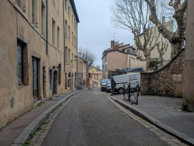 Fransa, Lyon 04 Şubat 2025: Tarihi mimarisi ve park etmiş araçları olan sakin şehir caddesi