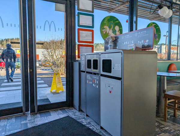 France, 31 December 2024 : Fast food restaurant interior showing recycling bins and outside view