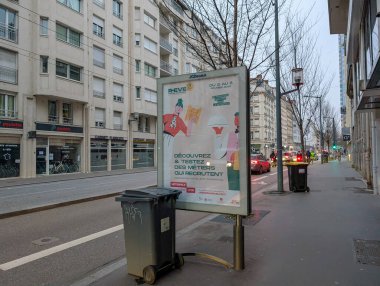 Fransa, Lyon 04 Şubat 2025: Reklamlı şehir kaldırımı, yoldan geçen insanlar, arka planda araçlar.
