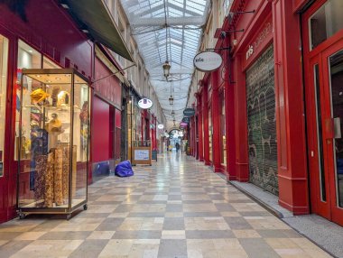 Fransa, Lyon 04 Şubat 2025: Paris 'te canlı vitrinler ve kırmızı mağazalarla kaplanmış alışveriş salonu