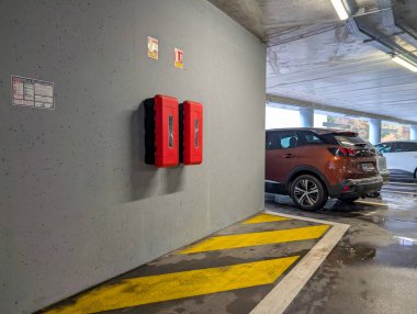 Fransa, 07 Aralık 2024: Acil durum ekipmanları ve park halindeki araçlarla yeraltı otoparkı