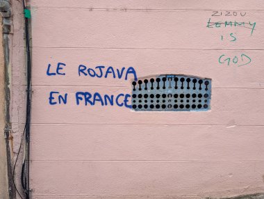 Fransa, Lyon 04 Şubat 2025: Pembe duvarda mavi ve yeşil kelimelerle graffiti