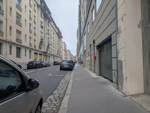 Fransa, Lyon 04 Şubat 2025: Sakin şehir caddesi binalar ve park halindeki arabalarla dolu