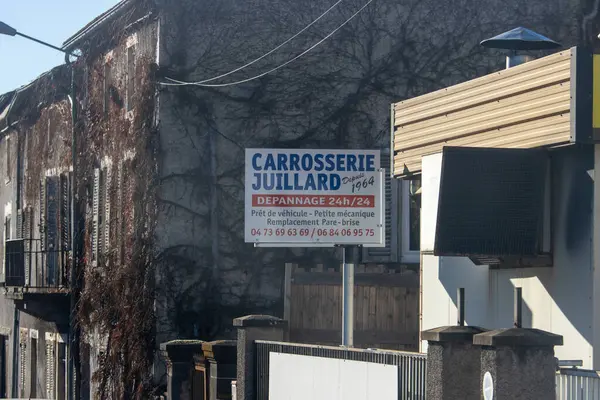 Fransa, 01 Ocak 2025: Sarmaşık kaplamalı otomobil tamirhanesi tabelası