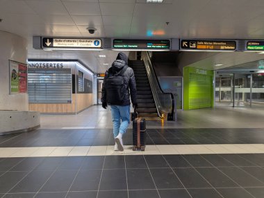 Fransa, Lyon 04 Şubat 2025: Çantalı gezgin boş modern ulaşım istasyonunda yürüyor