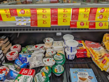 Fransa, 24 Mart 2025: Süpermarket koridorlarında çeşitli fiyat etiketleriyle sergilenen peynir ürünleri.