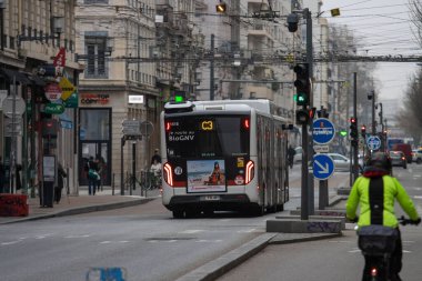 Fransa, Lyon 04 Şubat 2025: Bisikletçi ve yayalarla şehir caddesinde yol alan belediye otobüsü